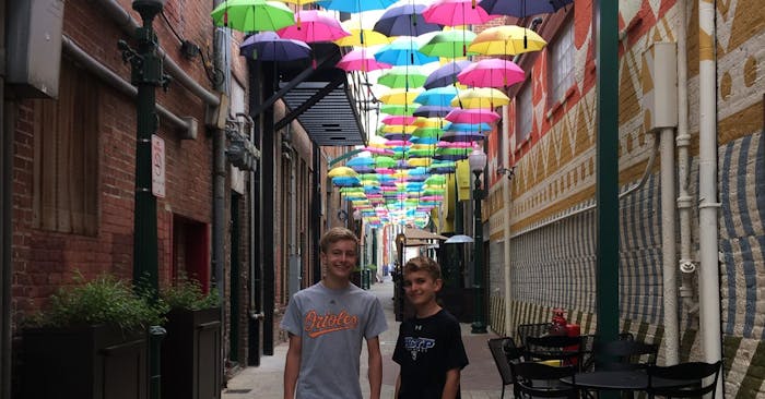Aidan and Ian in downtown alley covered in umbrellas