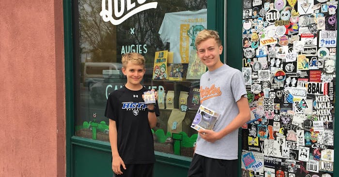 Aidan and Ian presenting their purchases in front of A Shop Called Quest