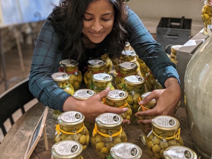 Employee, Nina, and jars of olives Lot22 carries to be paired with their oils and vinegars. 