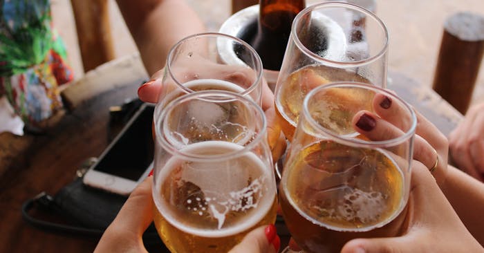 Group of friends raising their glasses together to cheers 