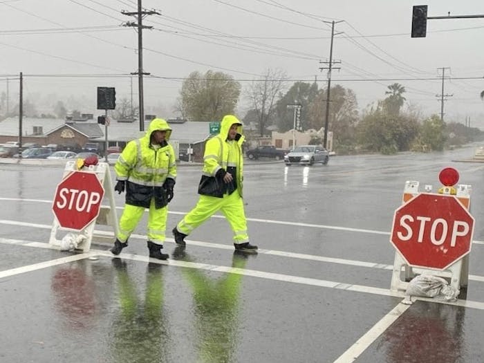 City of Redlands Teamster Employees putting temporary stop signs up in a dark intersection. 