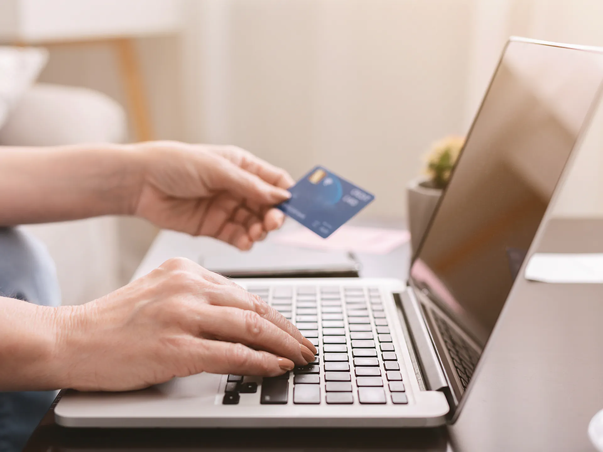 Hand with credit card looking at laptop