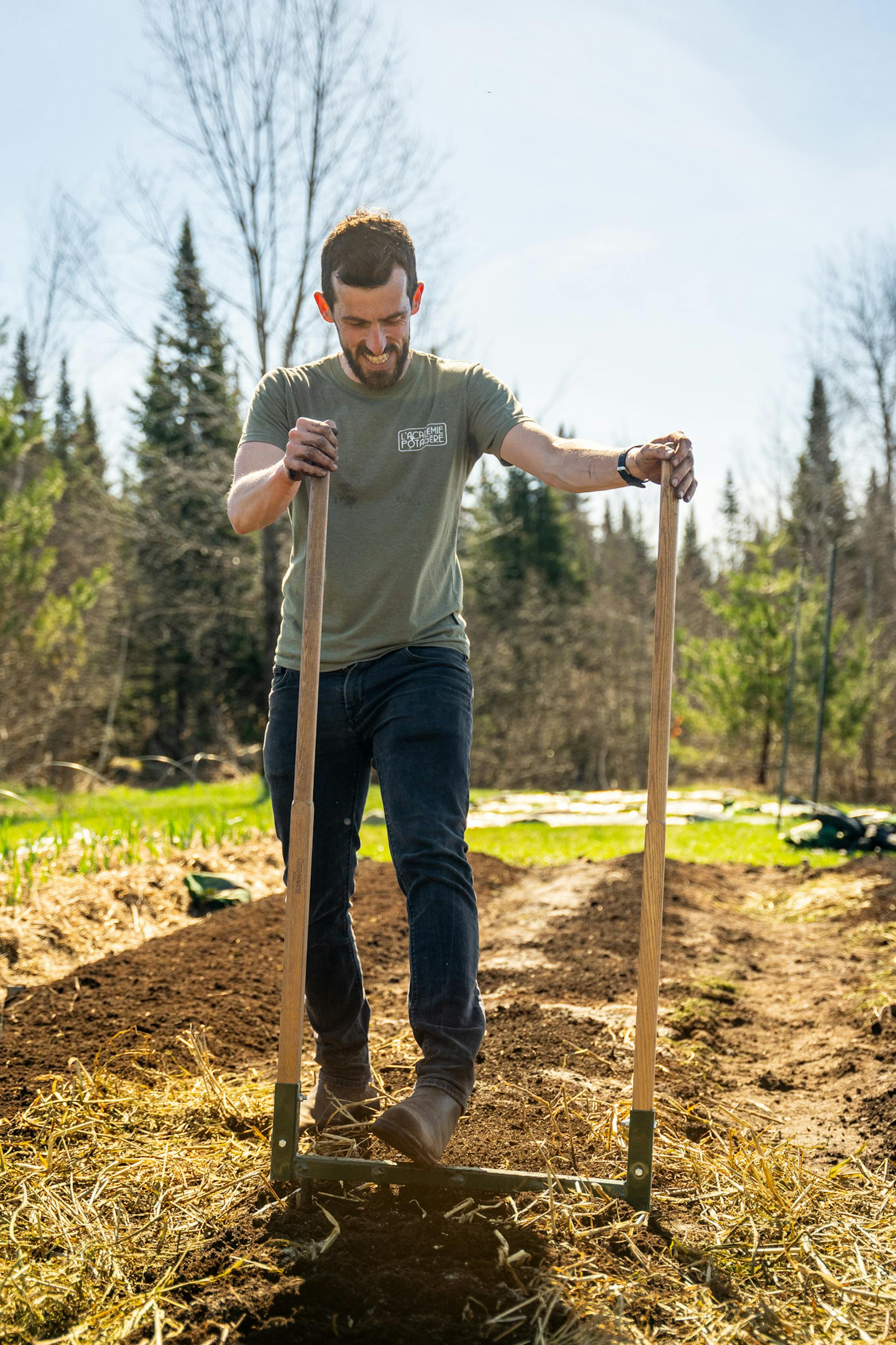 Jardinier sur une grelinette en train de préparer son sol.