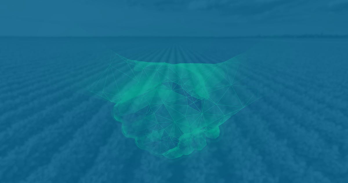 Two hands in a handshake, overlayed on an image of a vast field. The hands are glowing, and the photo has a blue filter.