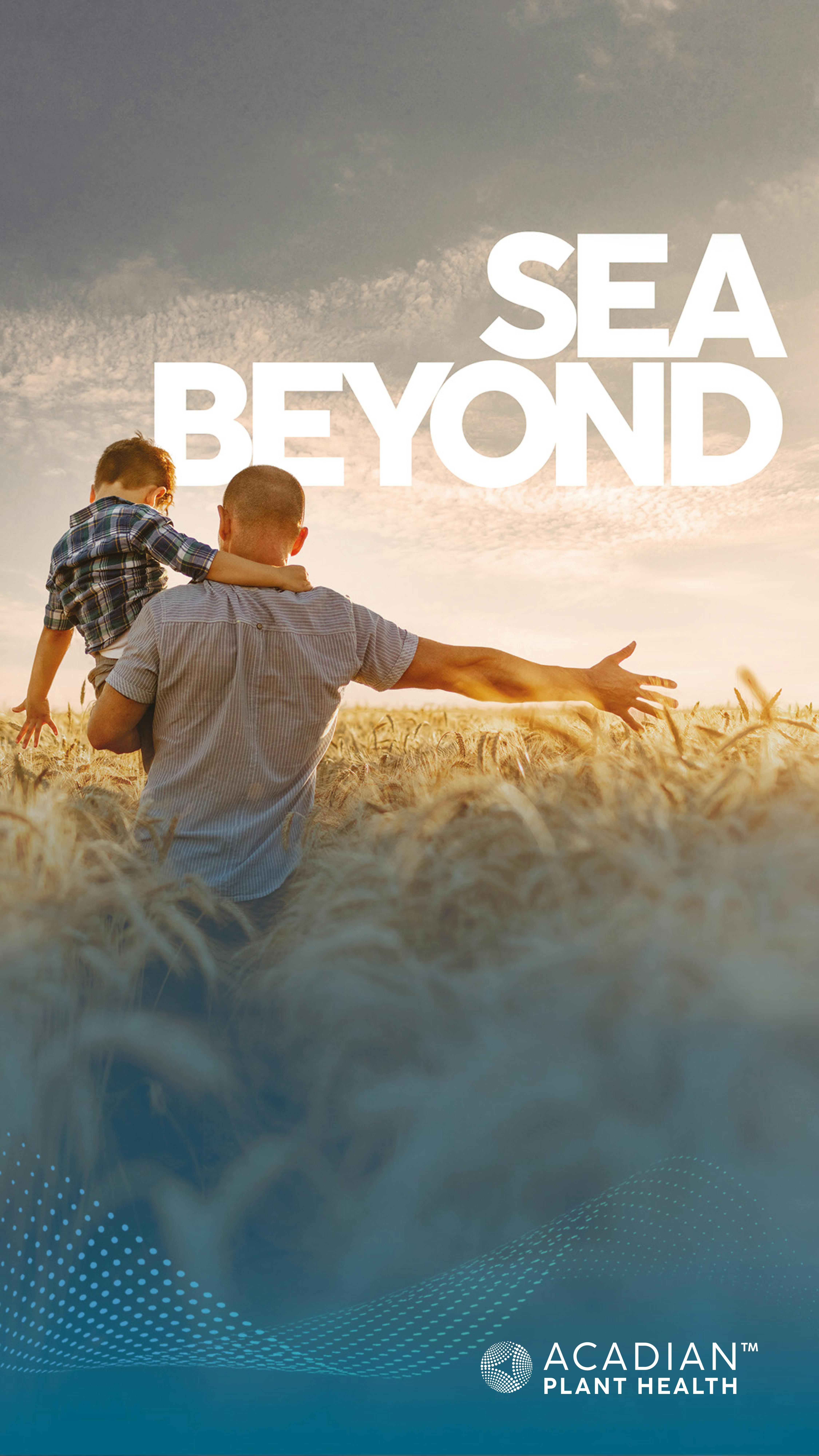 Homem com criança no colo num campo de trigo.