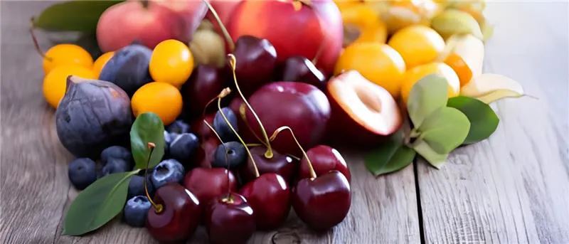 A variety of stone fruit on a wooden table.