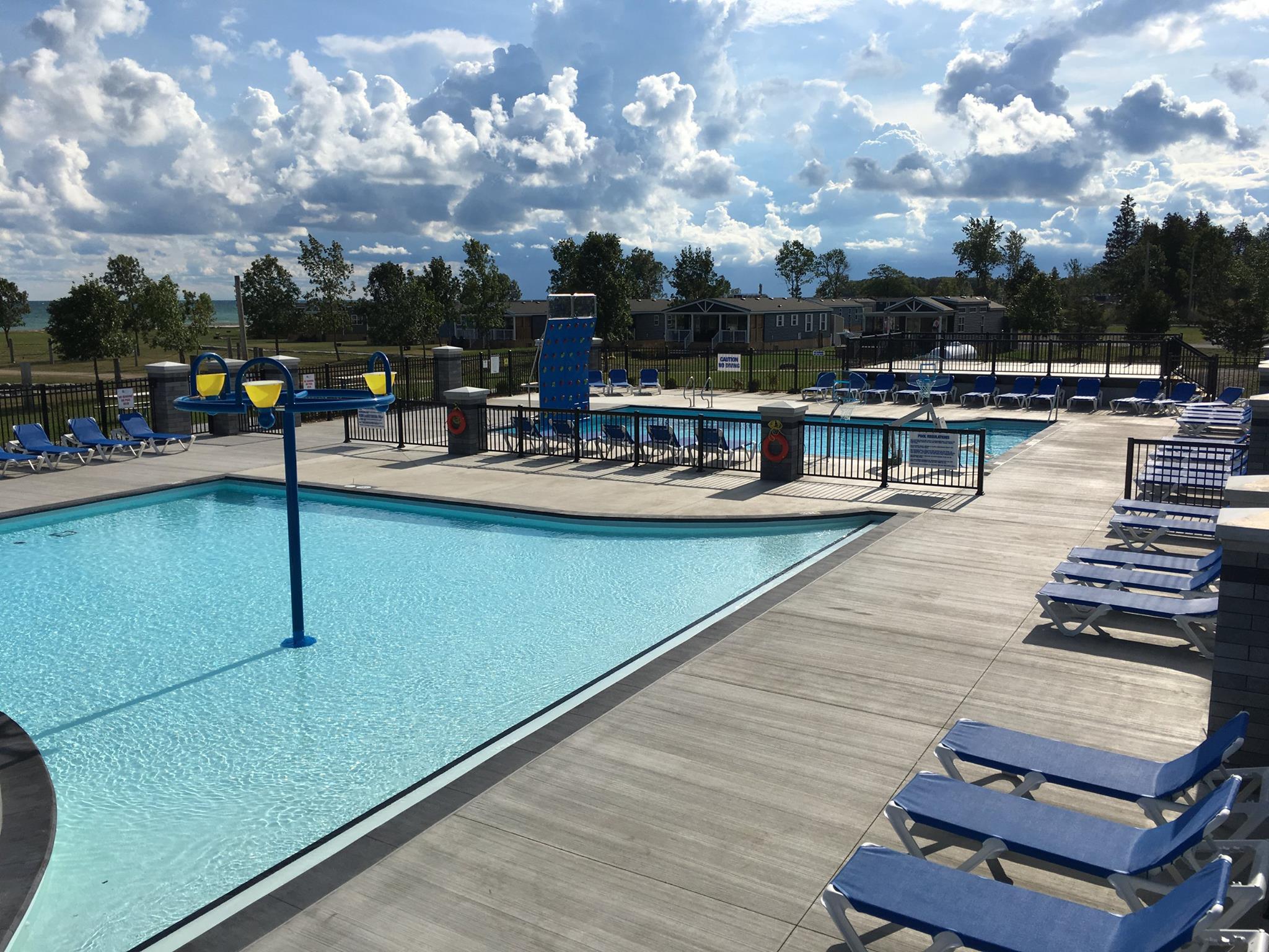 Outdoor leisure pool with blue and yellow tumble buckets.
