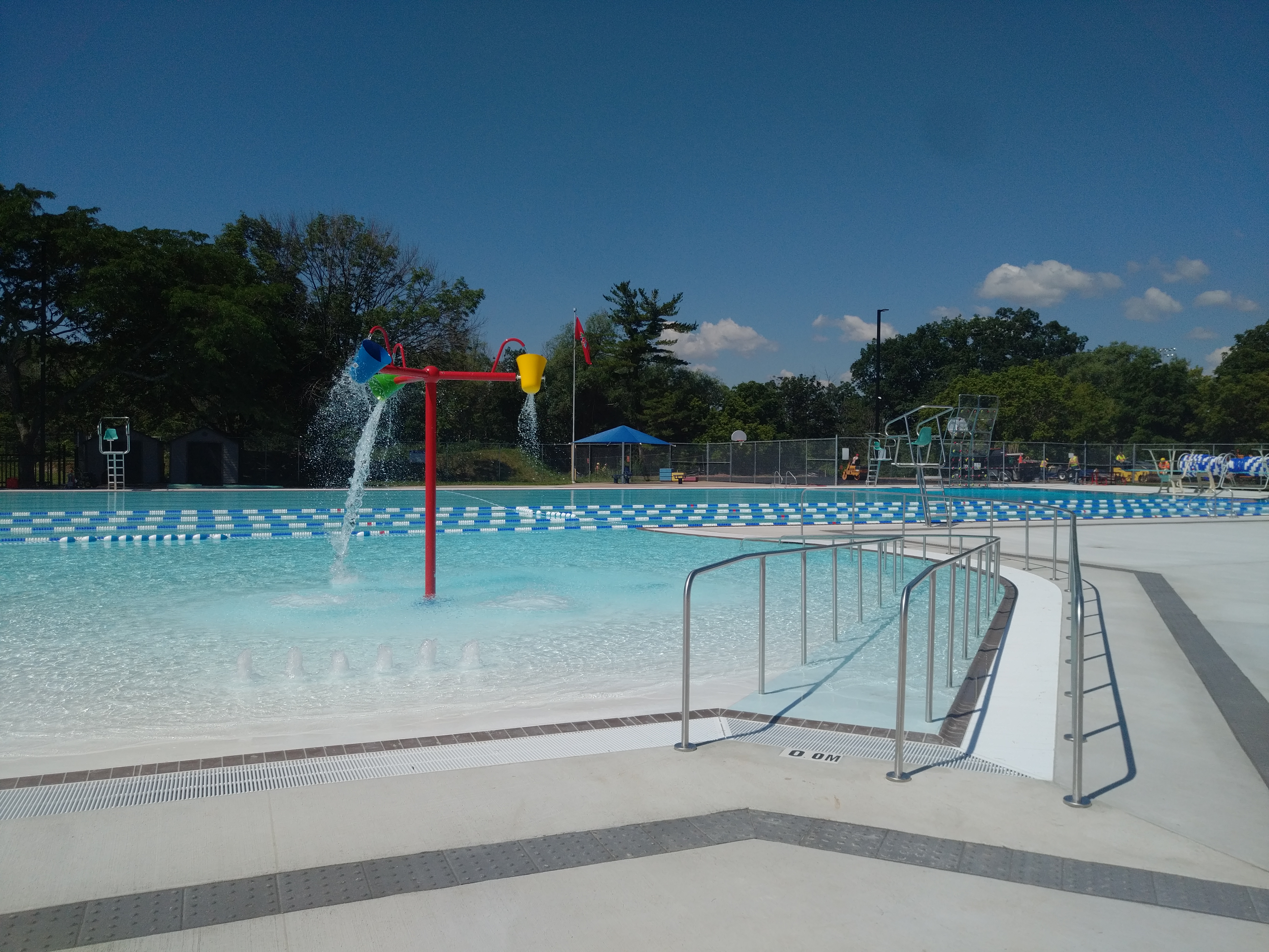 An outdoor leisure and lap pool on a sunny day. The pool has zero depth ...