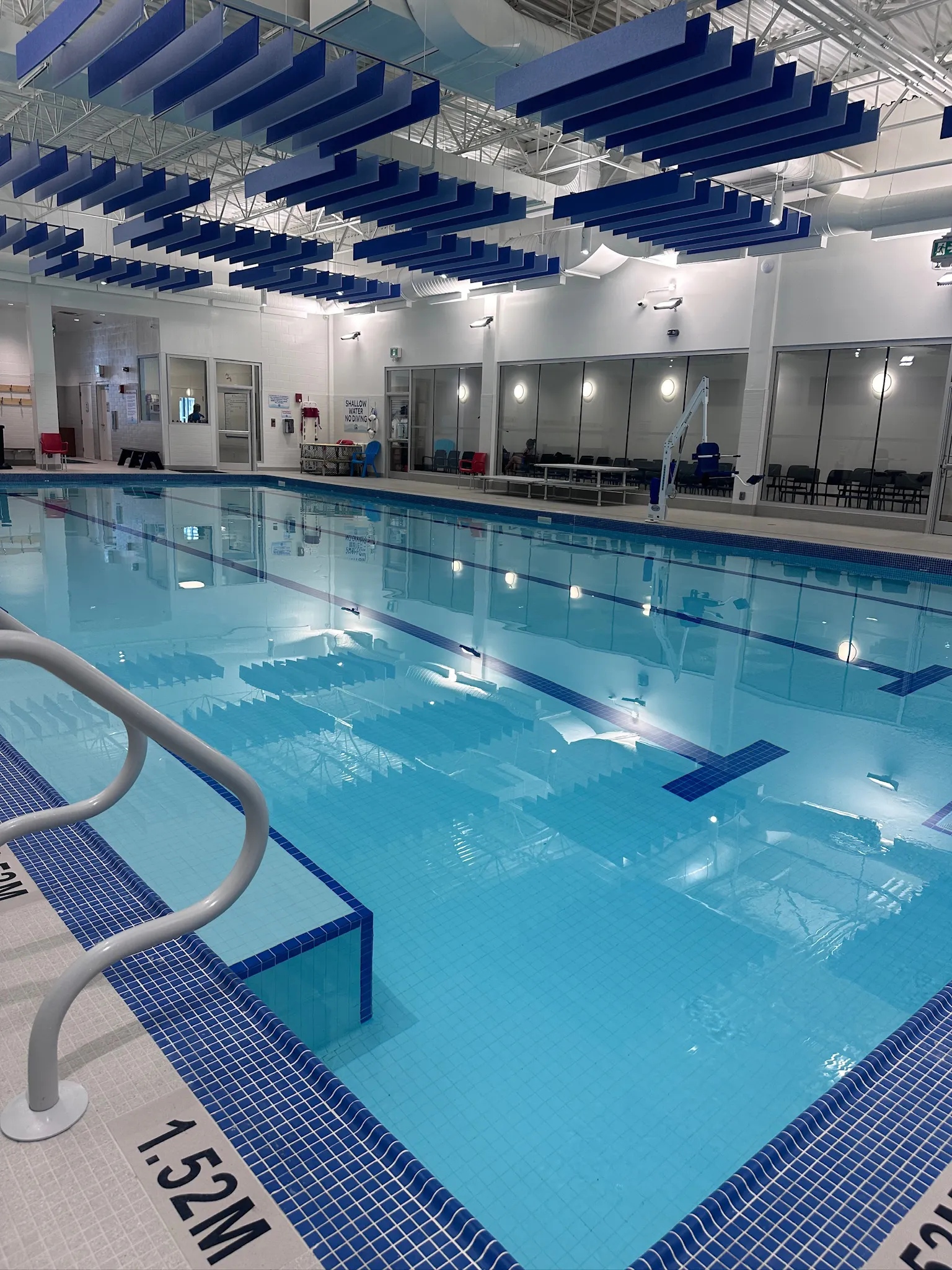 An indoor teaching pool with high ceilings with blue and white ...
