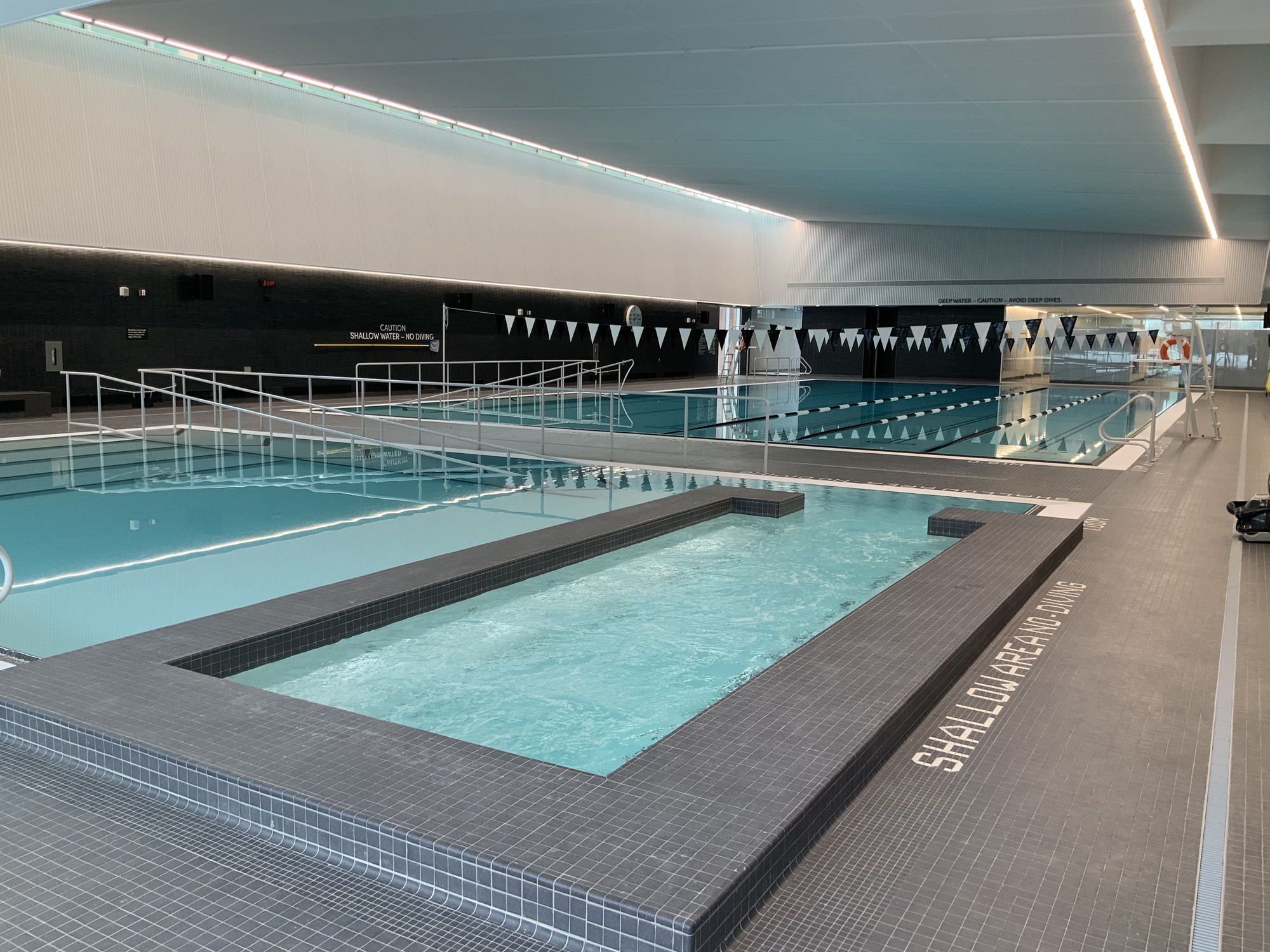 A modern indoor aquatic centre with two pools. One lap pool and a ...