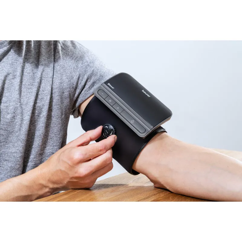 A digital home blood pressure monitor displaying a reading, used for monitoring hypertension at home as recommended by NICE NG136