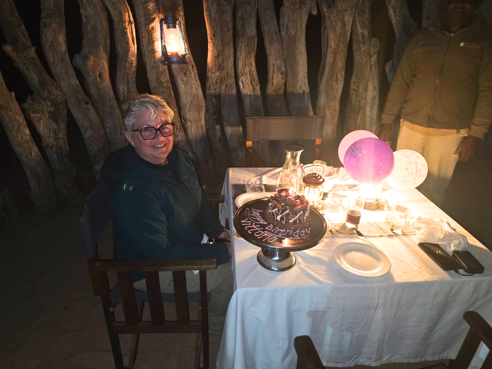 Vittoria Trainer - Sat at table with birthday cake and balloons on the Okavango project
