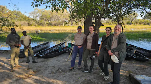 A group of volunteers next to the canoes of the Mokoro boat trip in the Okavango - Martin Coombes