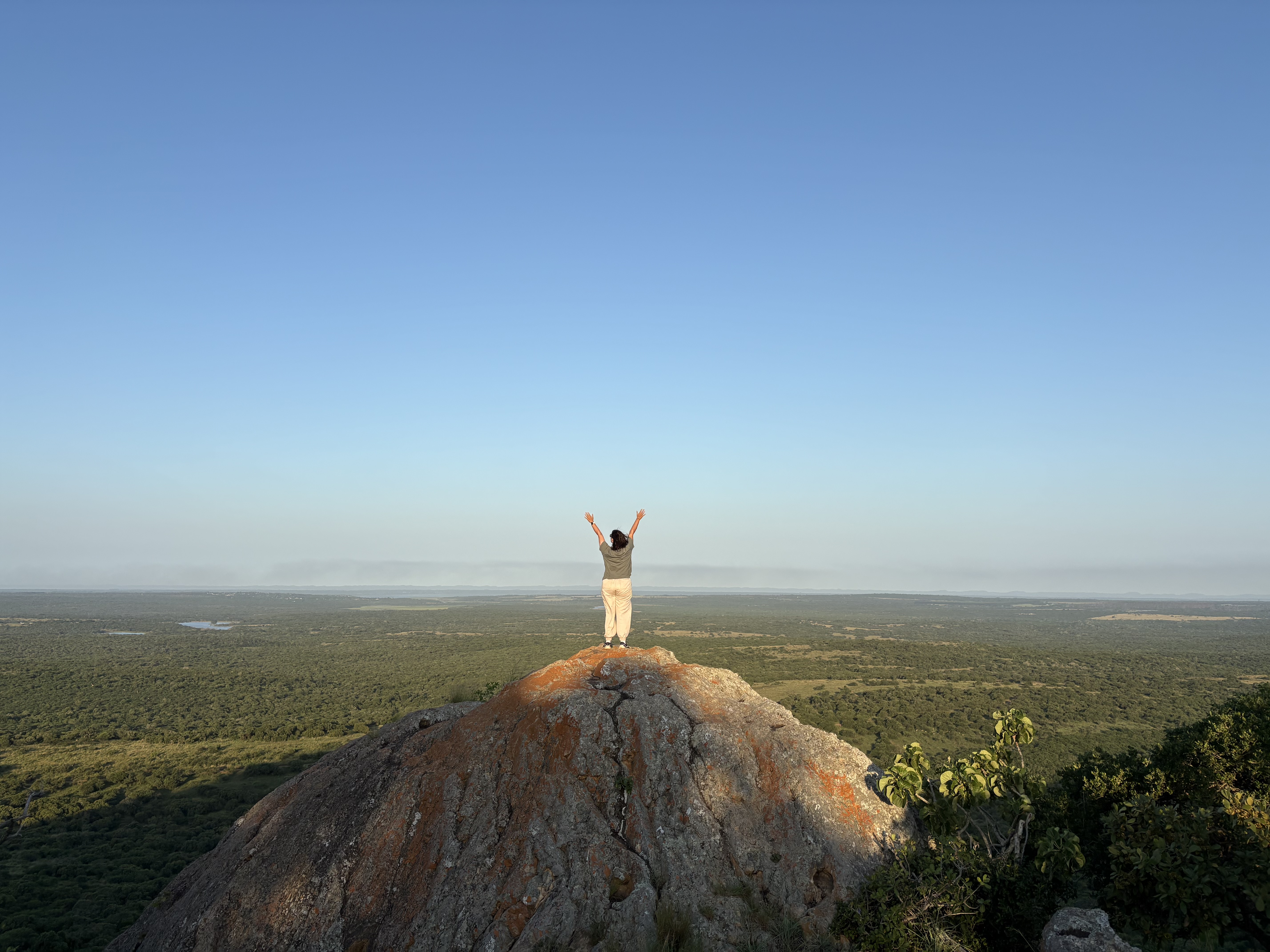 GVI: volunteer posing on top of a rock