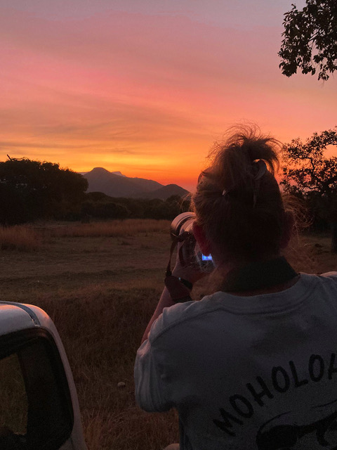A female ACE volunteer looking across a sunset