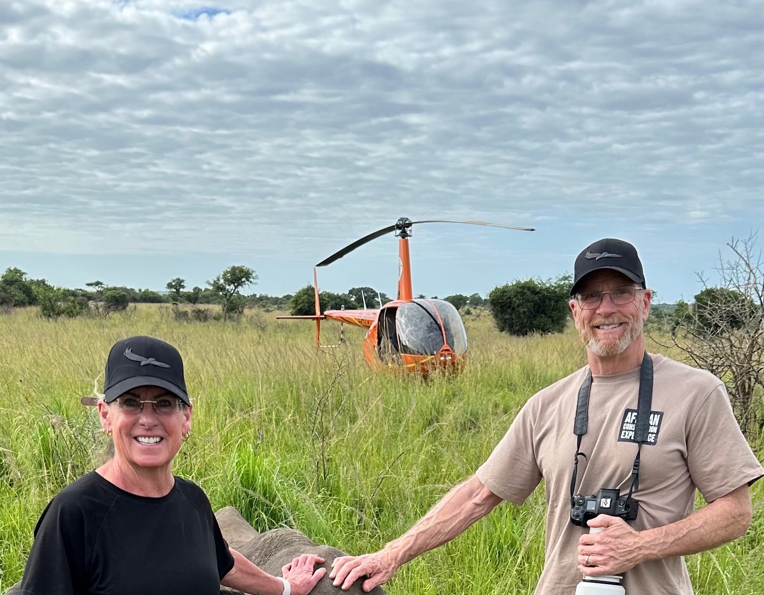 Mark and Jean Skilling: Volunteers in front of a helicopter 