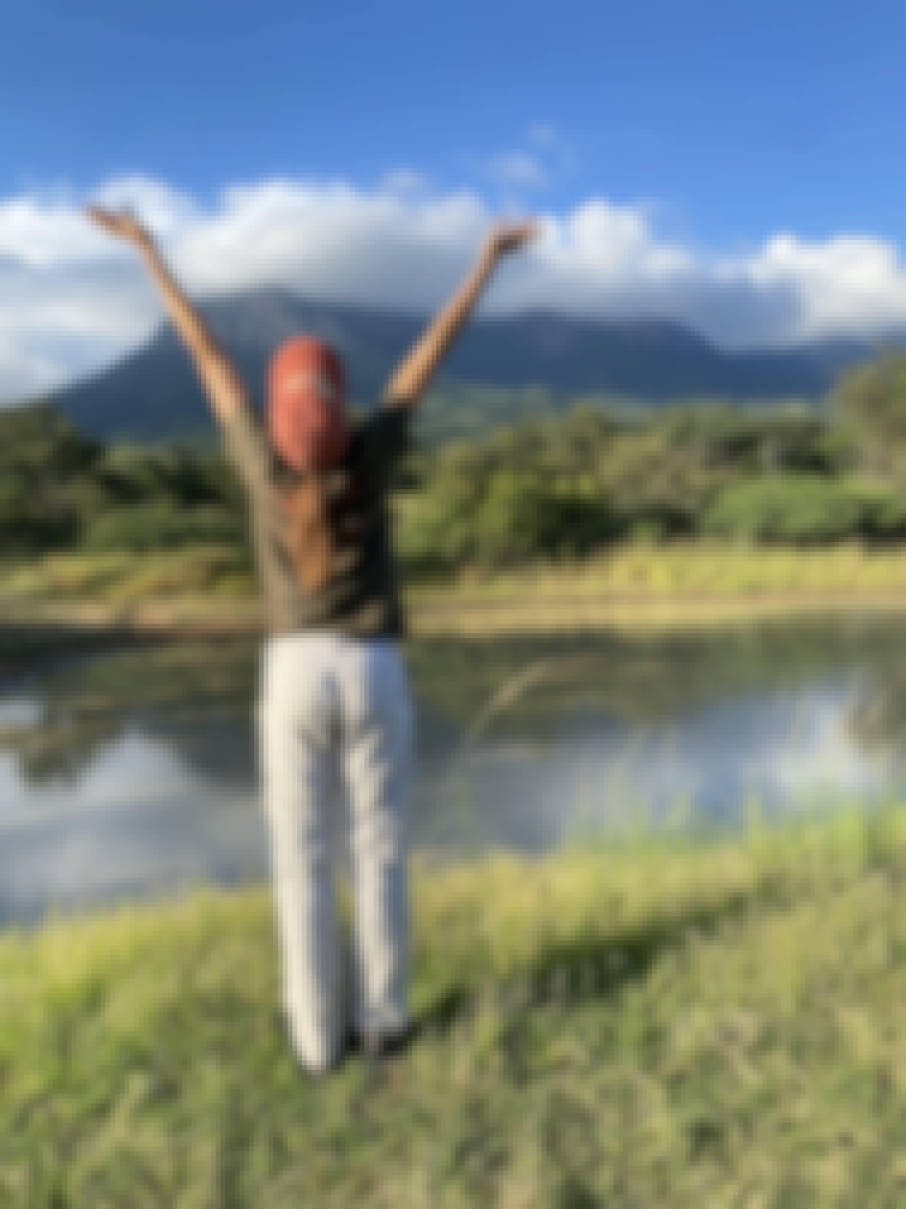 A girl cheers in front of a beautiful landscape at Moholoholo