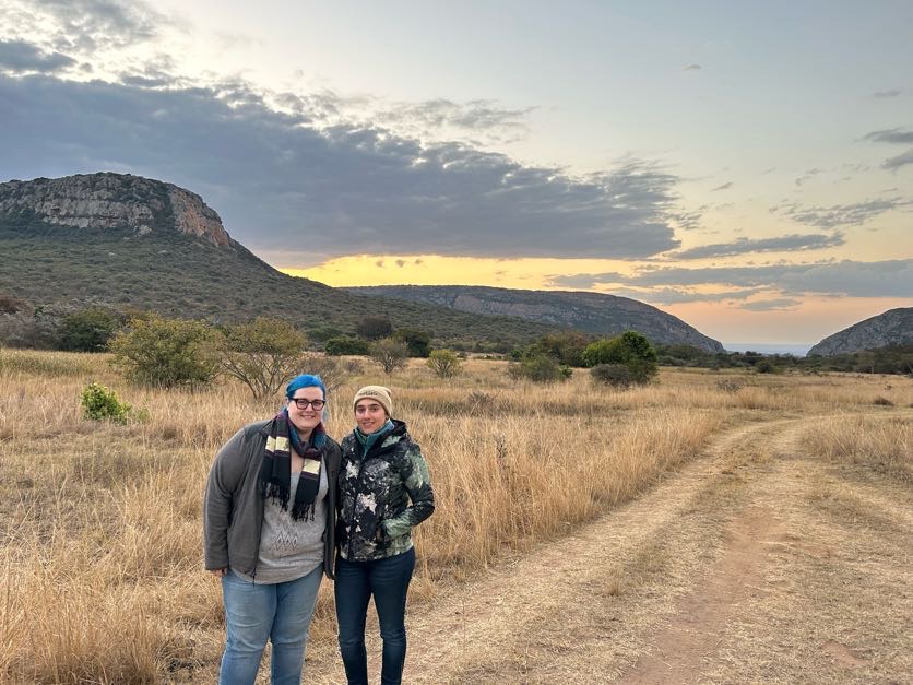 Kaitlyn Evans: two female students stand in front of mountains 