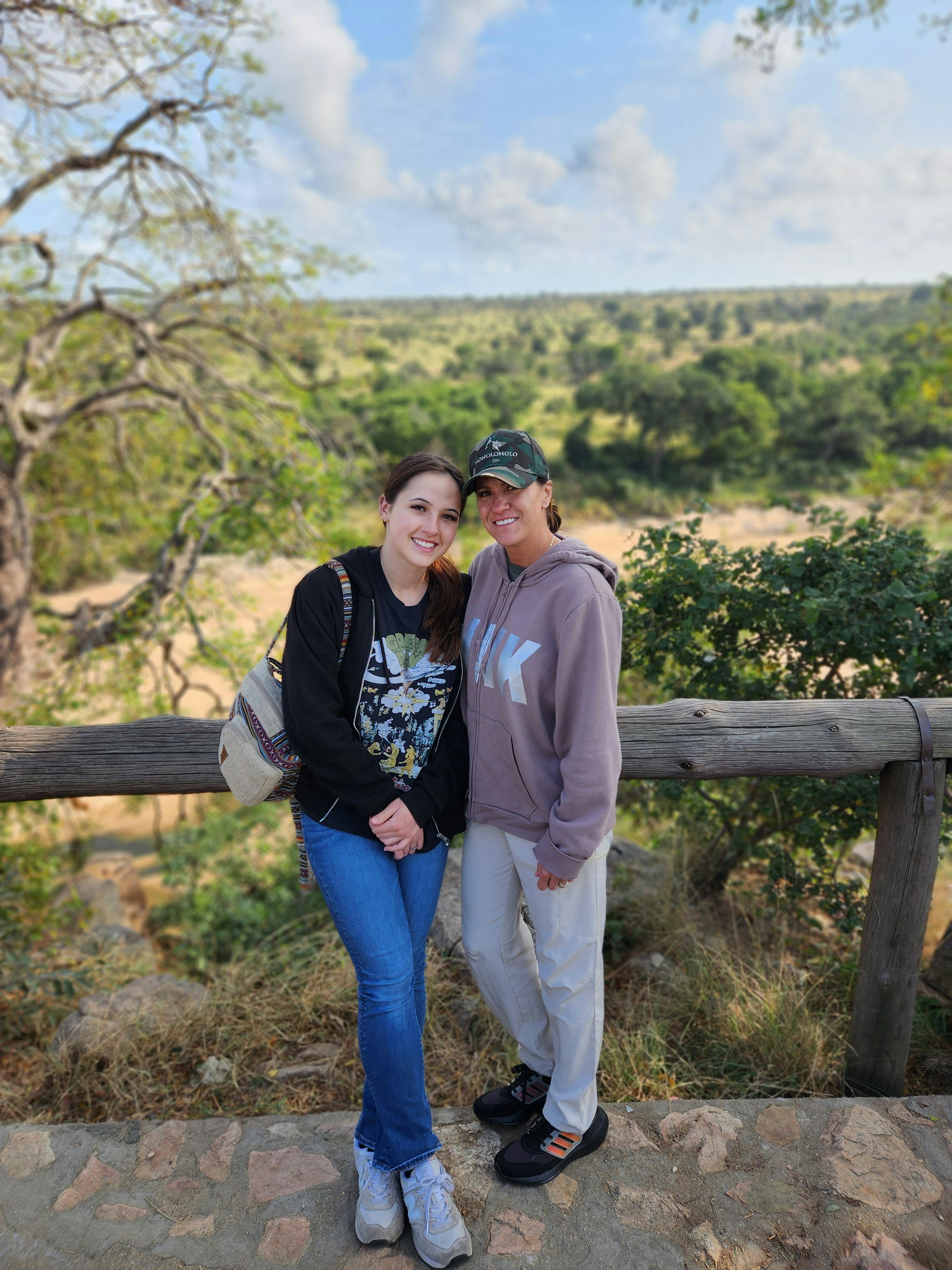 Two women stand in front of a plain