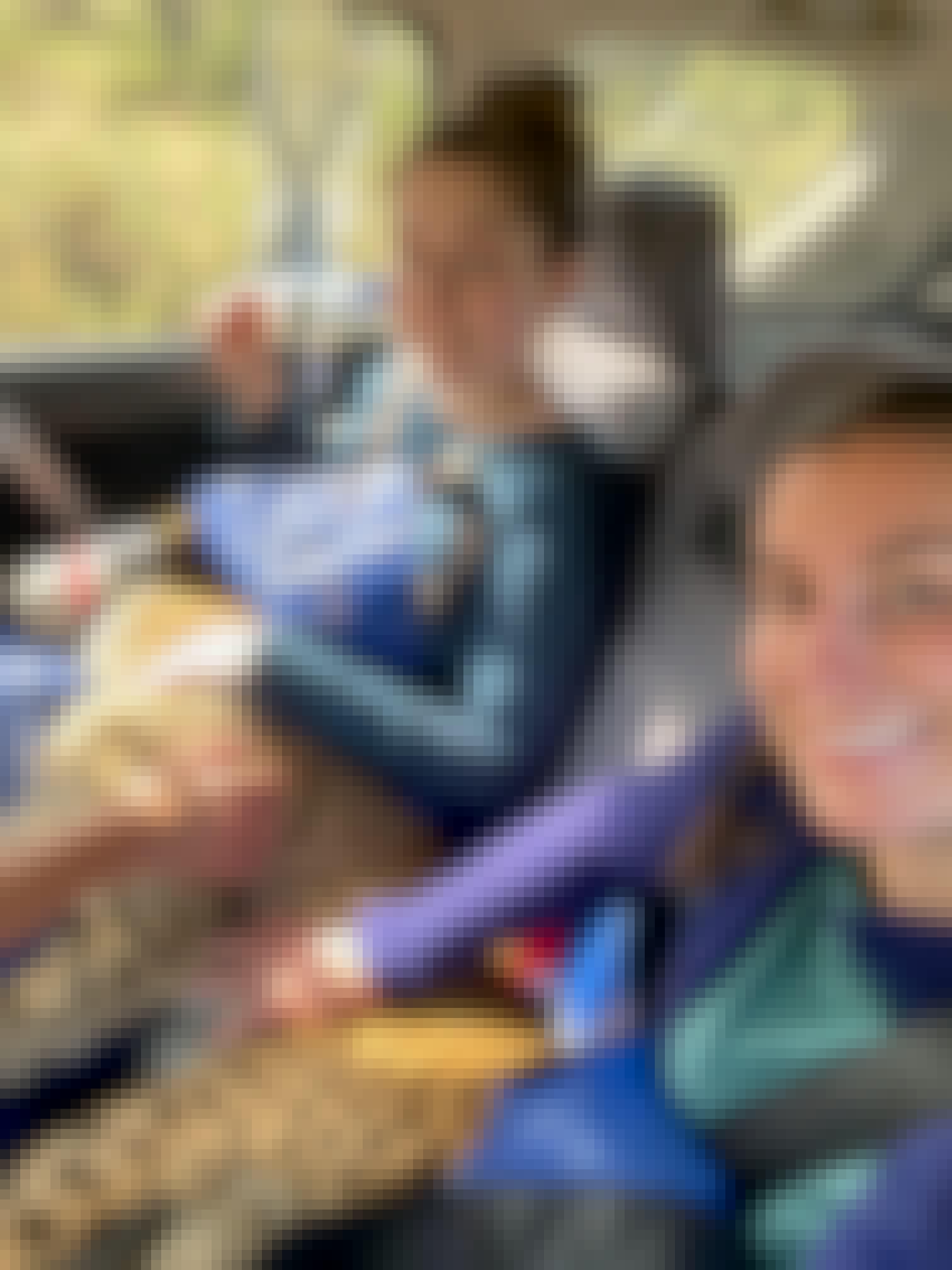Two female volunteers hold a sedated cheetah in a vehicle 