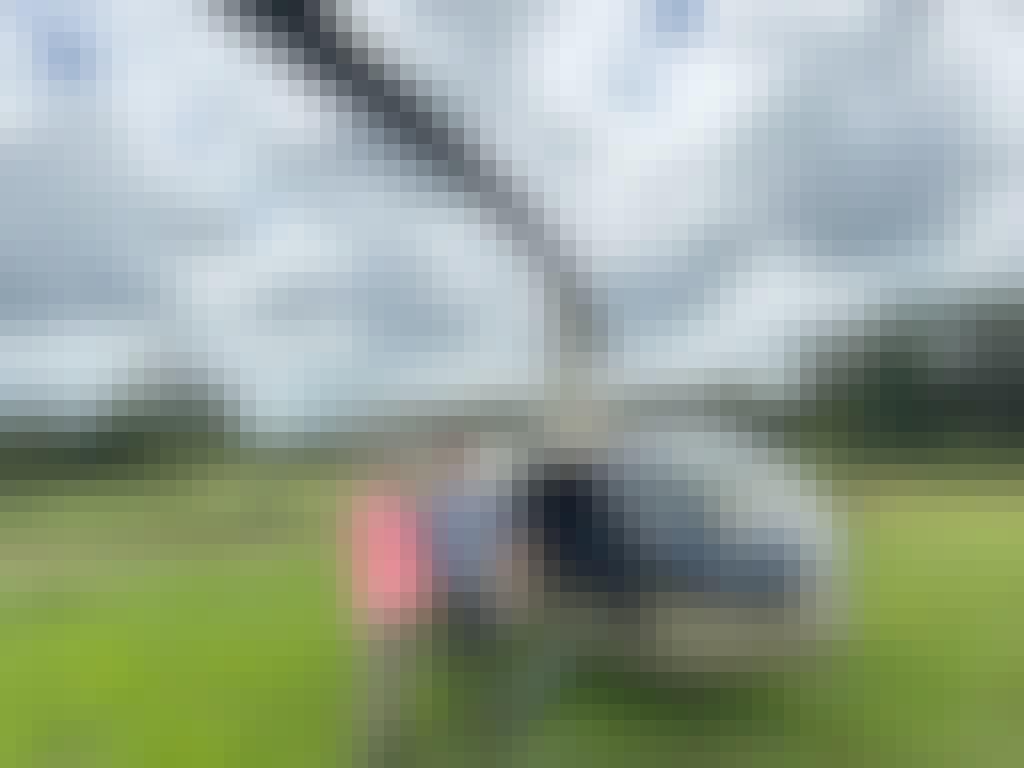 a couple pose in front of a helicopter