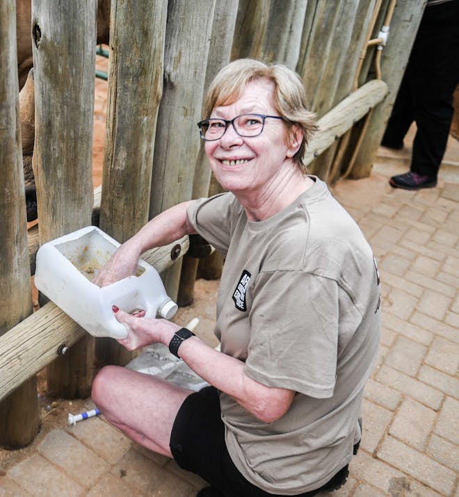 Norma Falconer: smiling at the camera while feeding the rhinos at Care for Wild Africa