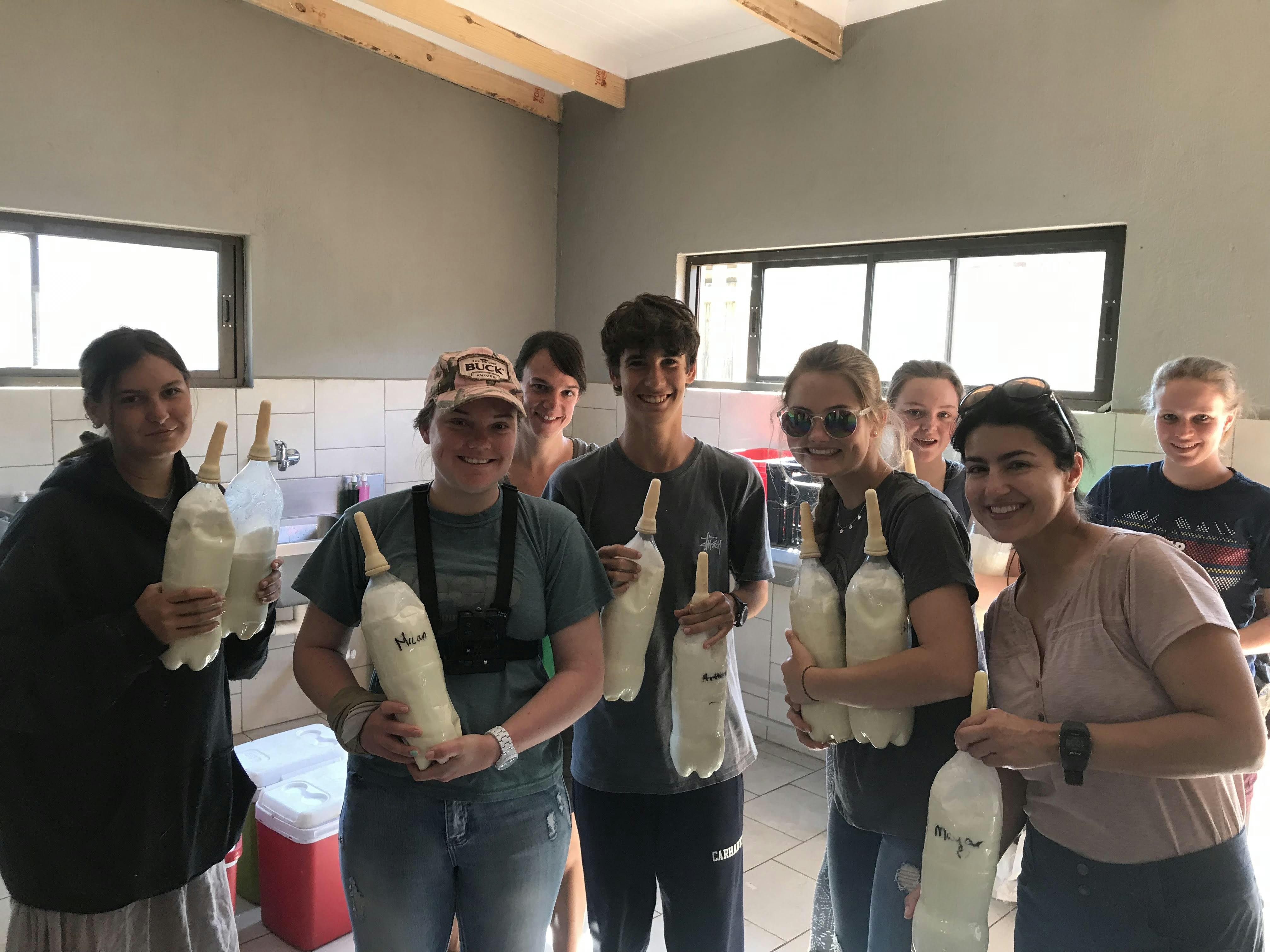 Nina Kubicek: group posing with bottles of formula for rhinos