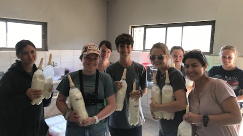 Nina Kubicek: group posing with bottles of formula for rhinos