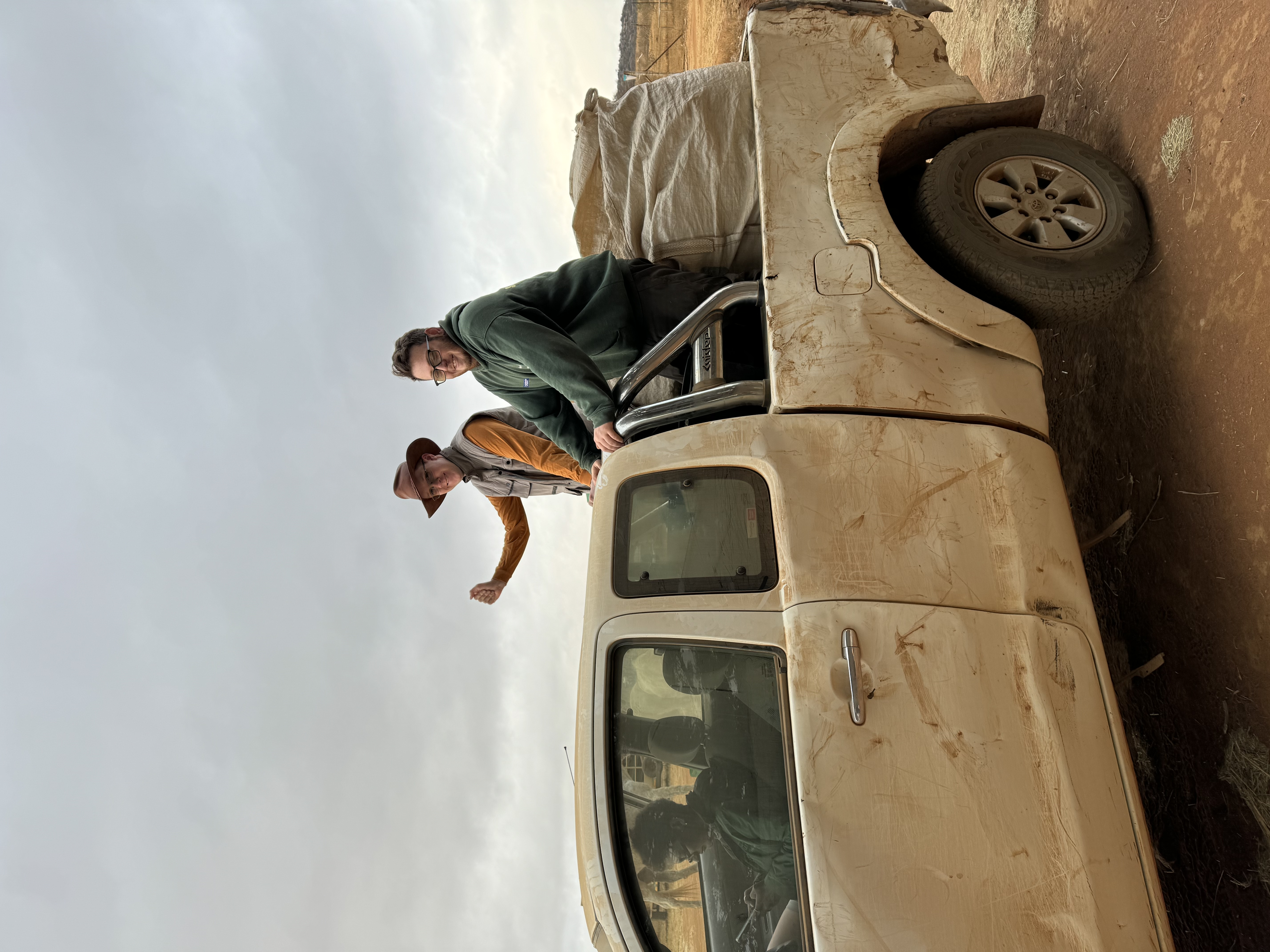 Amanda Thompson: two male volunteers smiling on the back of the truck 