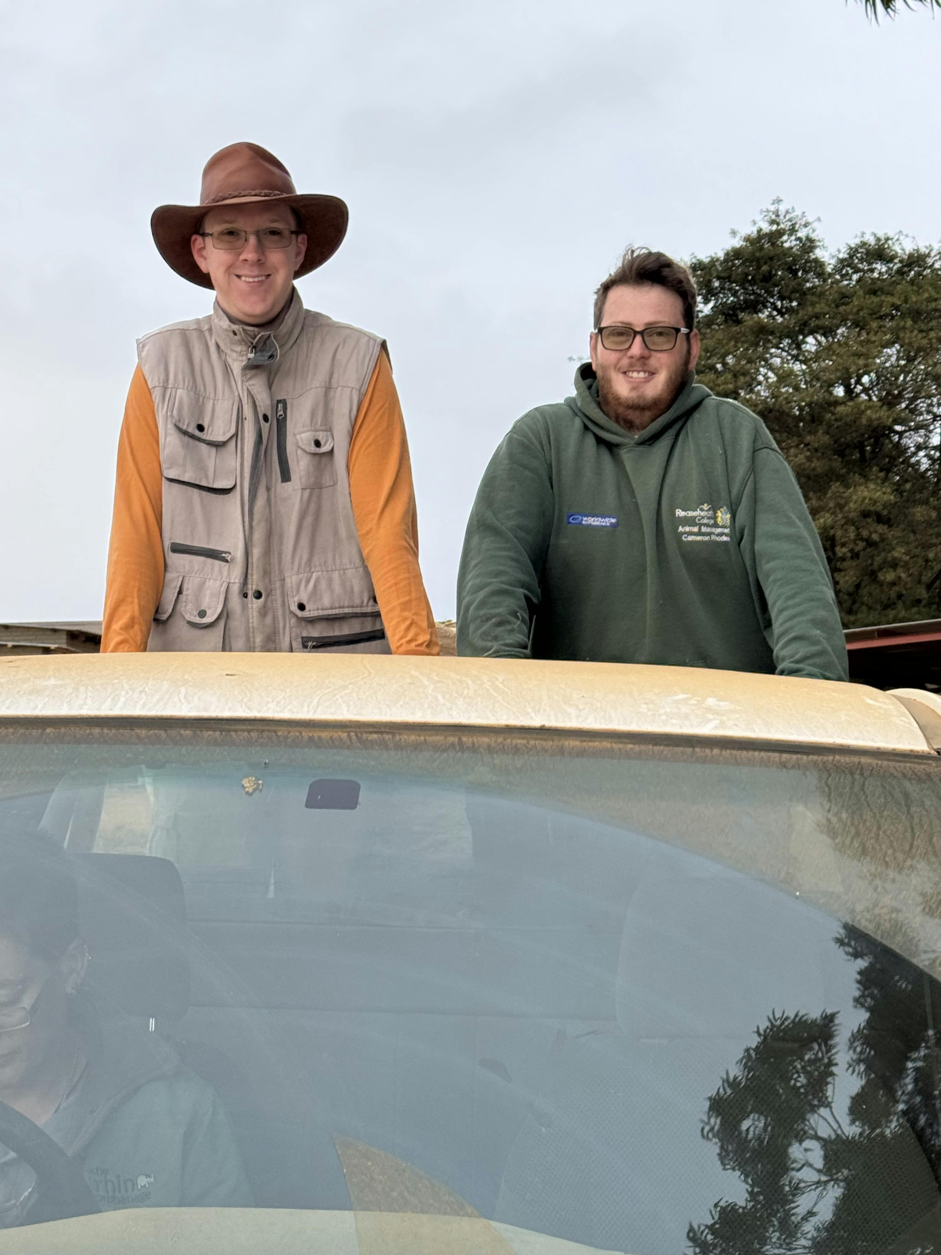 Amanda Thompson: two male volunteers posing on the back of the truck