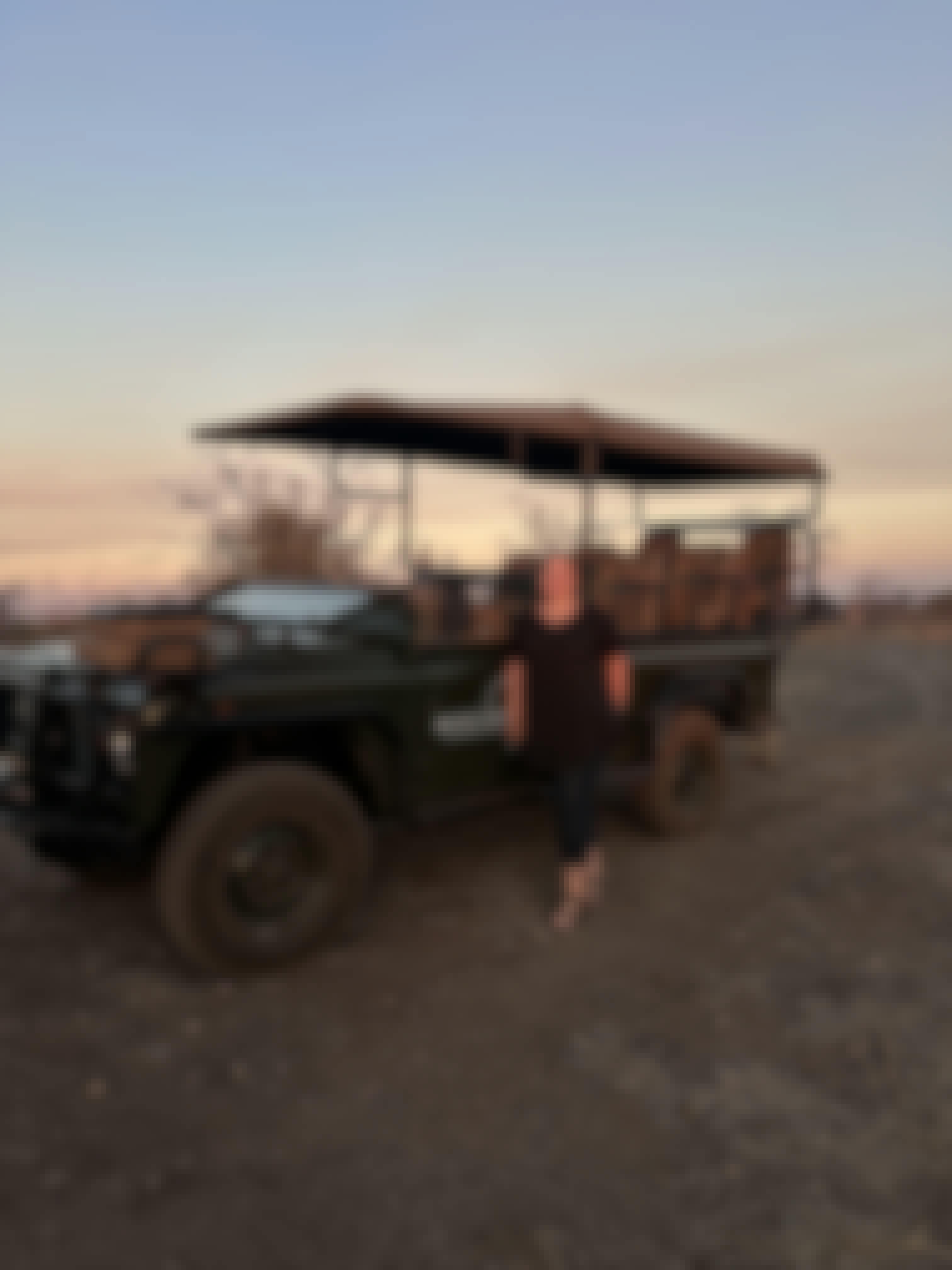 Volunteer standing next to a safari vehicle