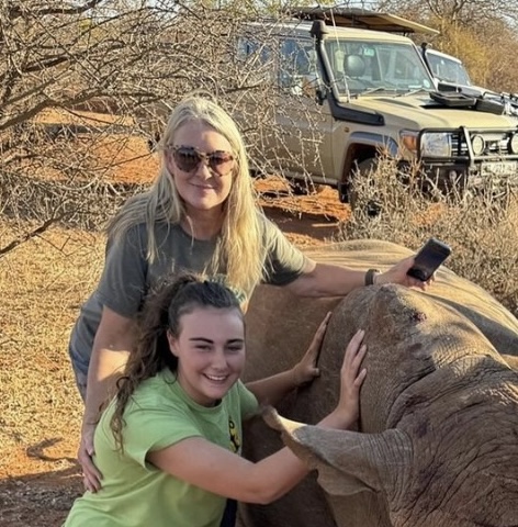 Kathy and Katie: Volunteers standing next to a sedated rhino