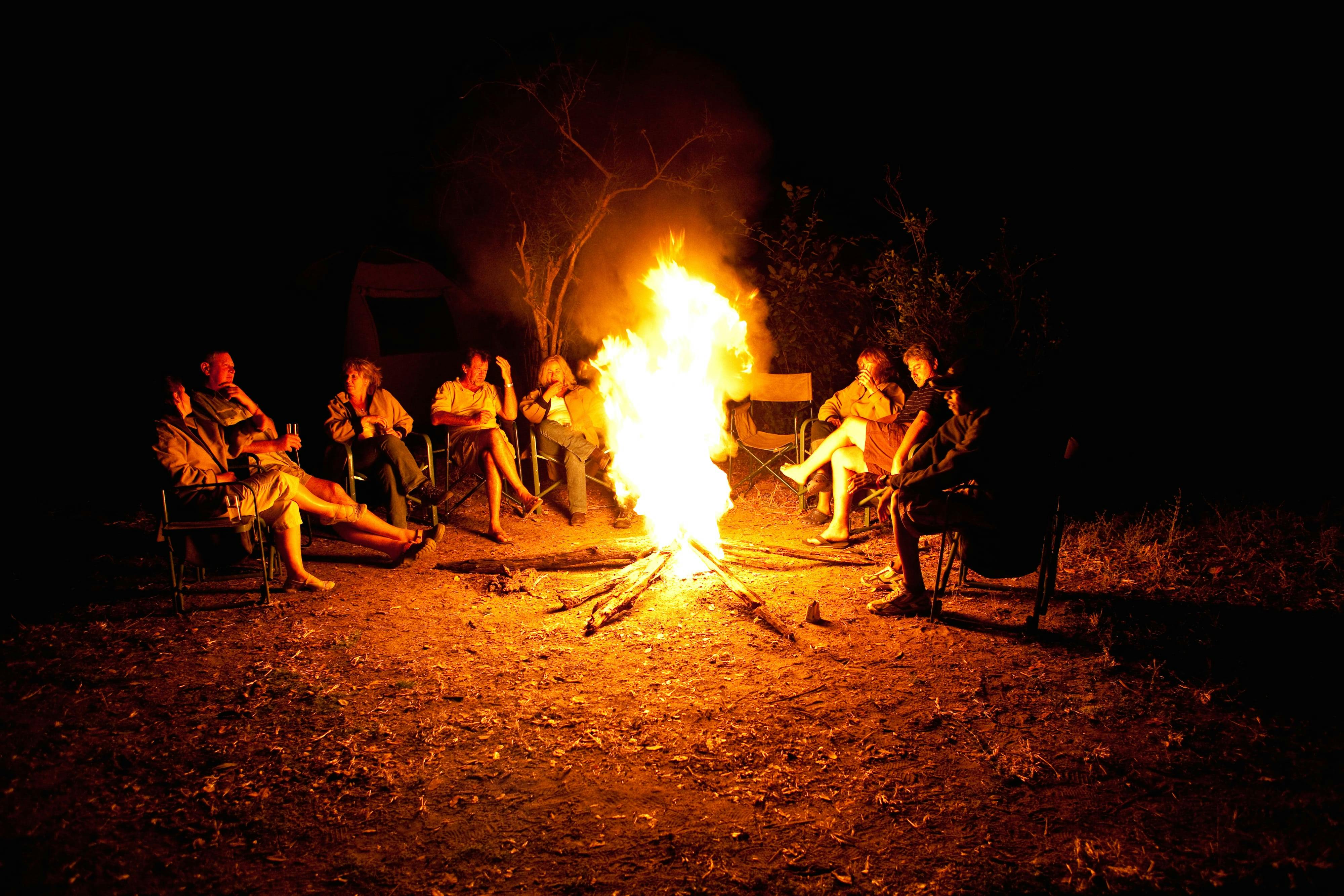 Group of ACE volunteers relaxing around the campfire