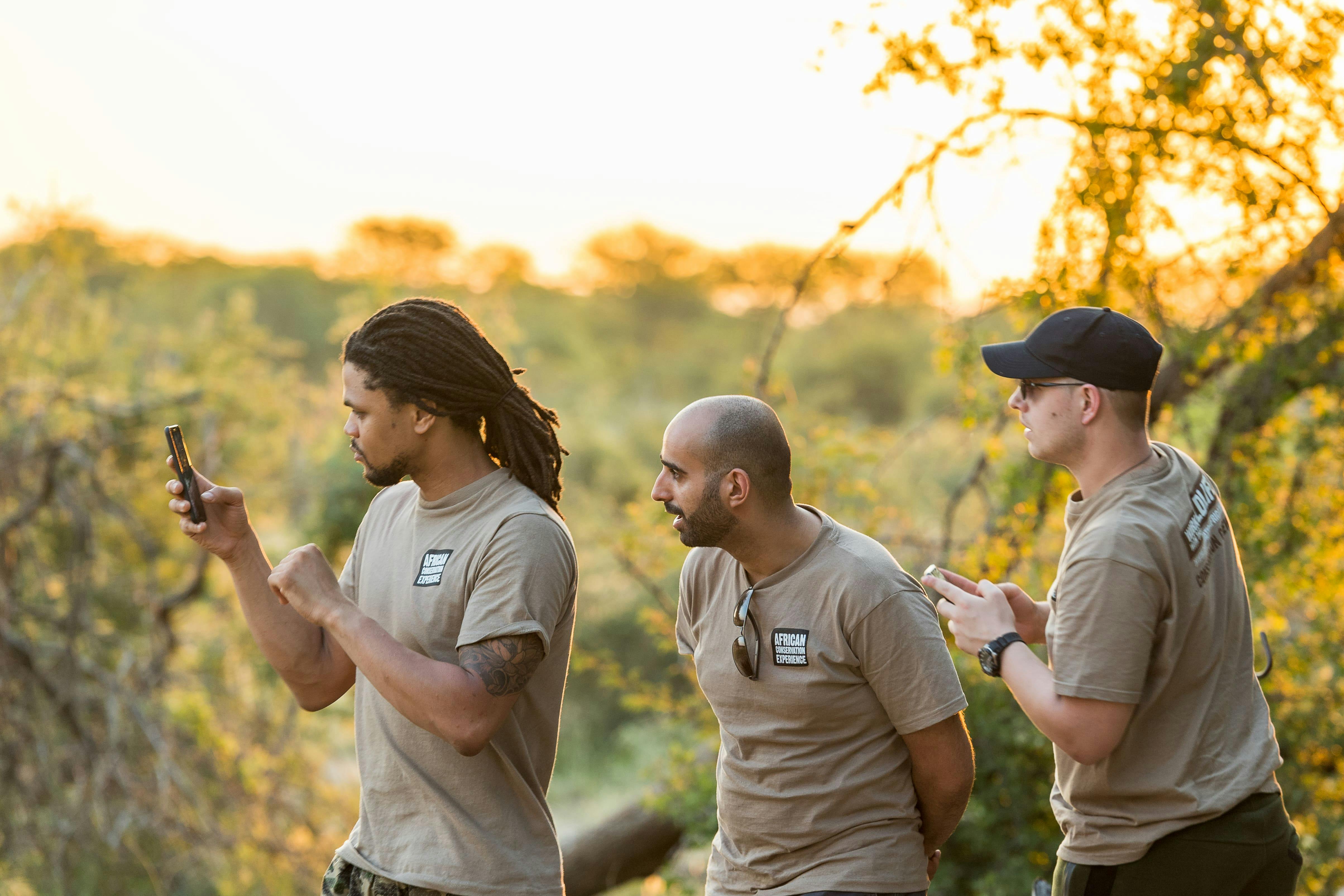 Group of male ACE volunteers taking photos in the Okavango