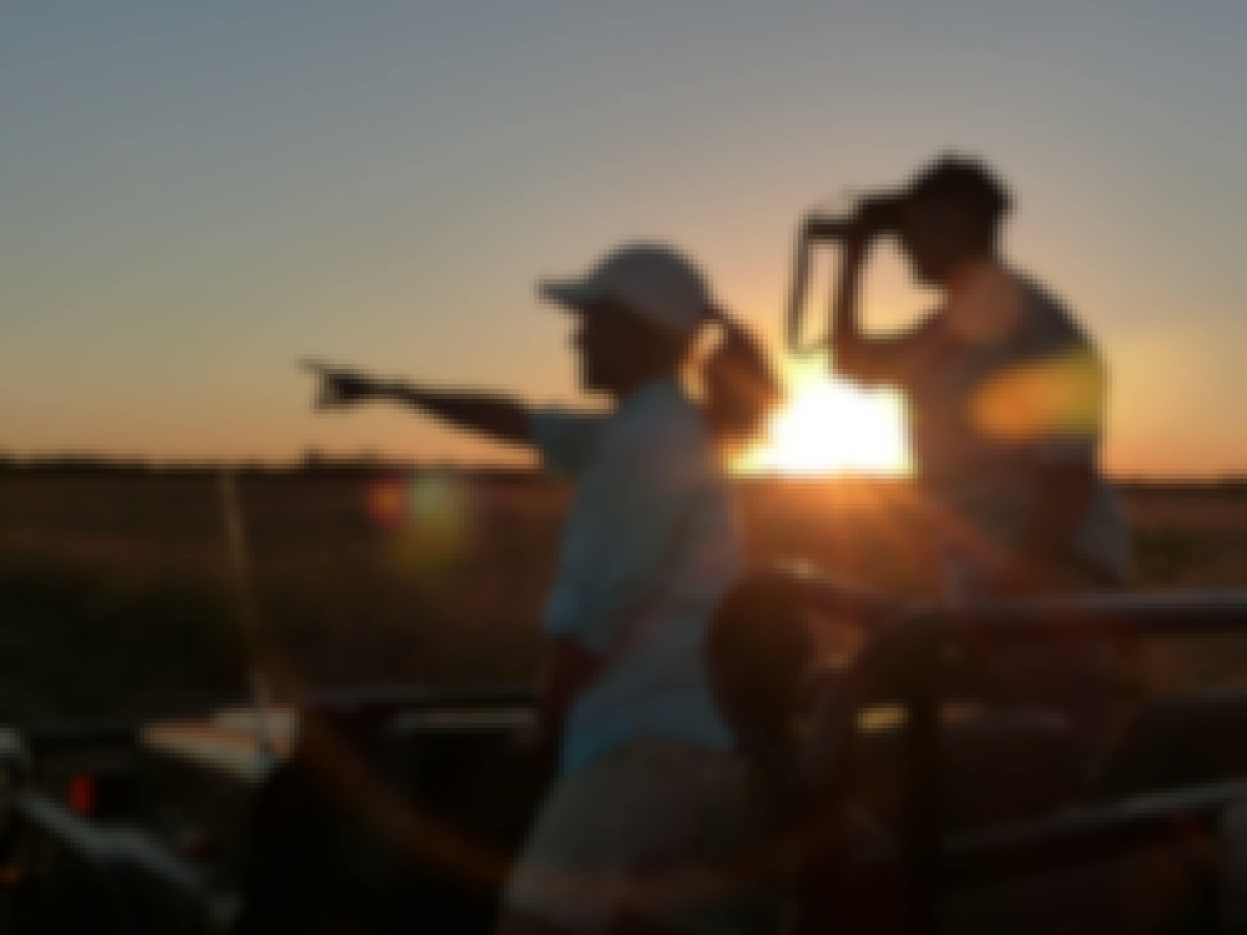 2 ACE volunteers observe wildlife from a jeep at sunset on the Phinda reserve