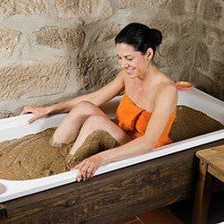 A woman in  bath full of mud