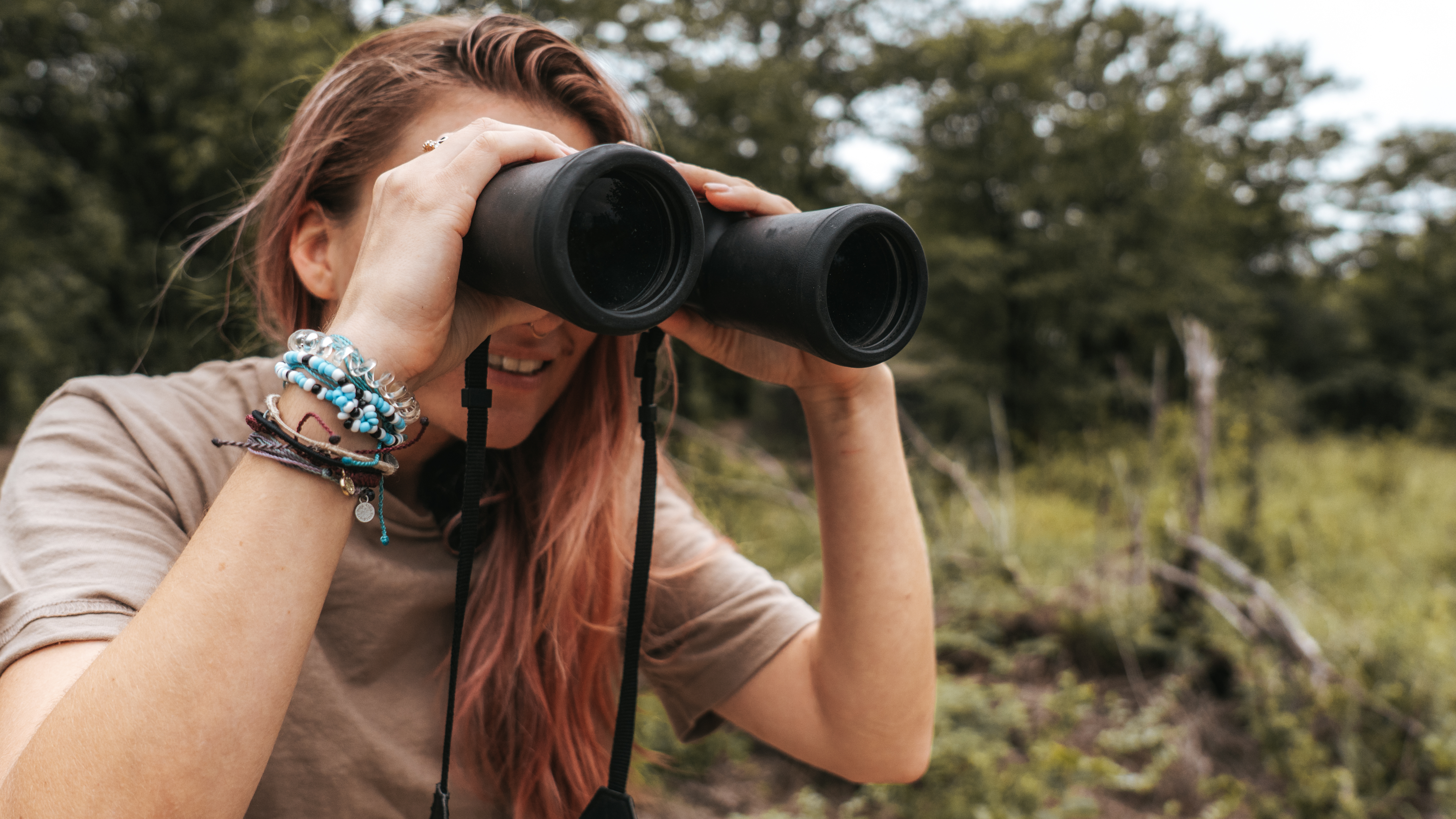 Categories A-Z - Volunteer looking through binoculars in the Okavango