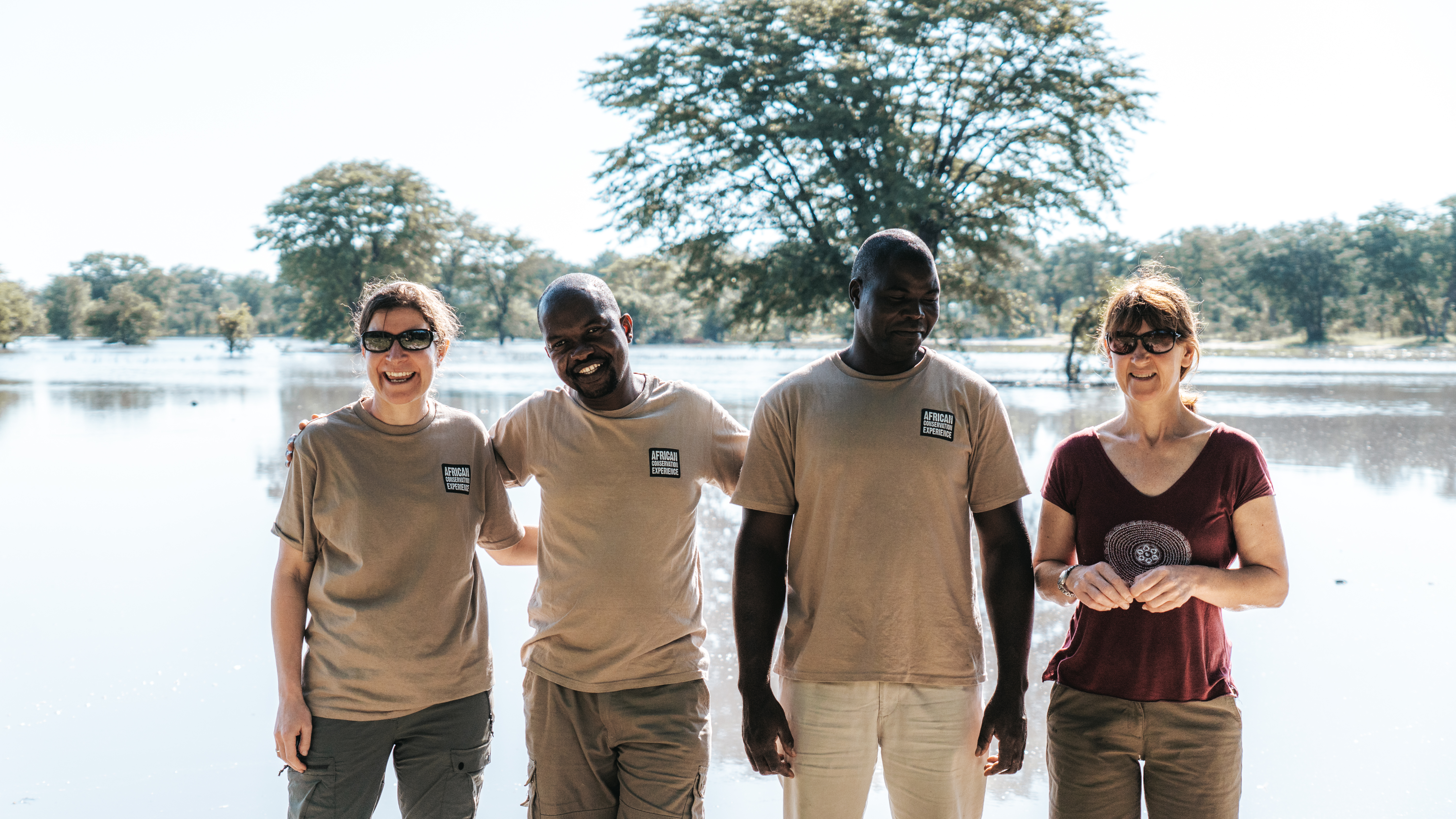 Short term volunteer work abroad - Short term volunteer work - Volunteers smiling with their guides in front of a lake