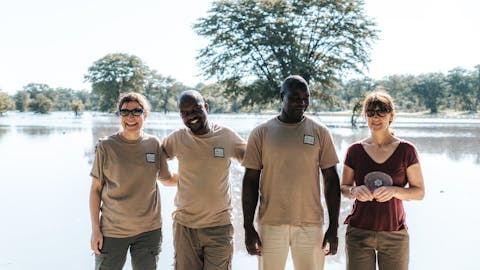 Short term volunteer work abroad - Short term volunteer work - Volunteers smiling with their guides in front of a lake
