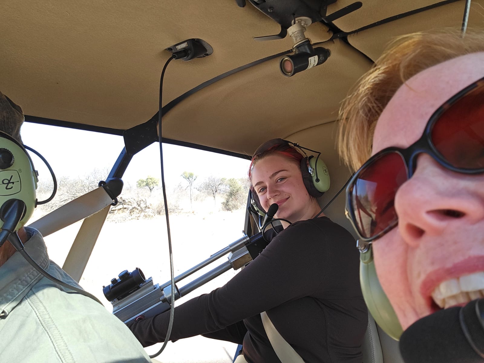 Wildlife vet volunteer - Wildlife veterinary experiences - Vets students smiling in a helicopter shooting a dart gun