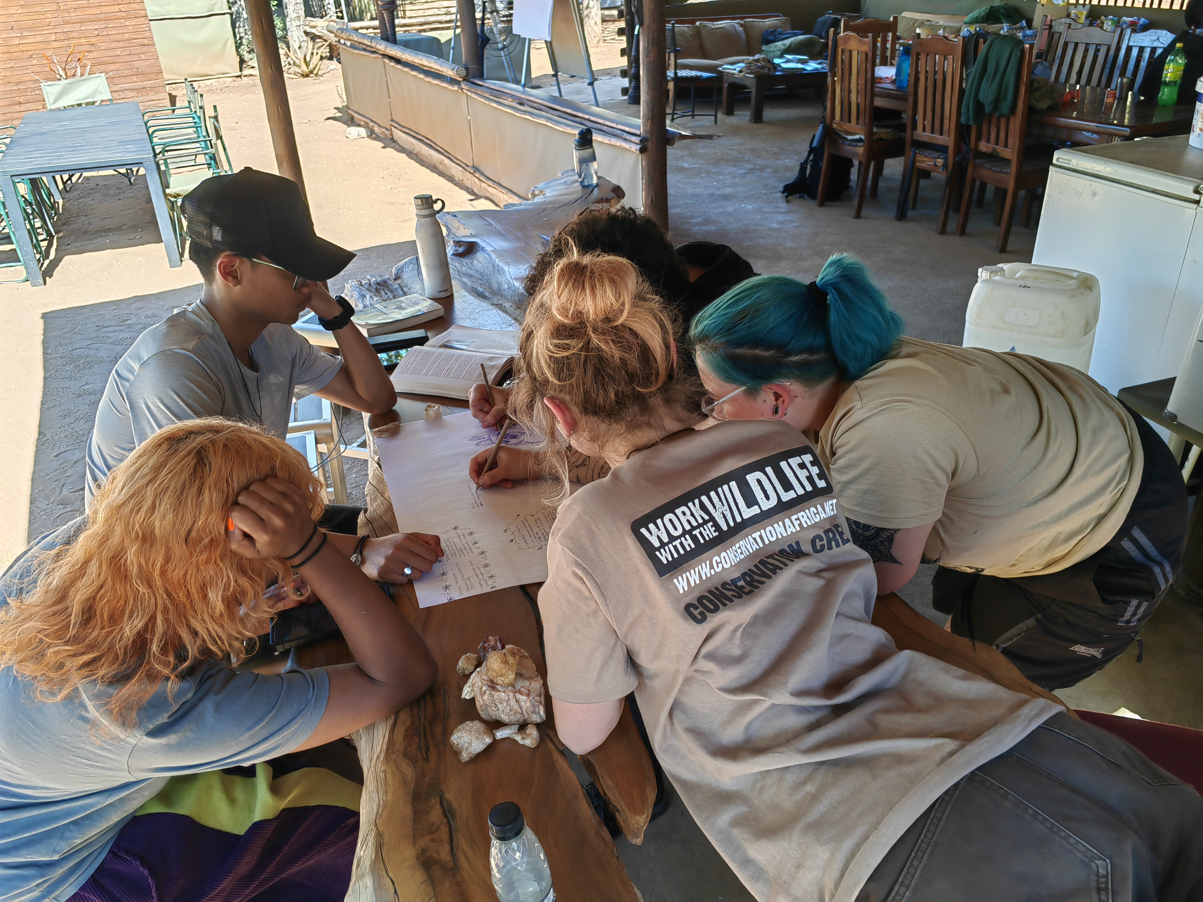 Animal care and conservation field trip to africa - Animal Care Field Trip -  Group of volunteers gathered around a table working