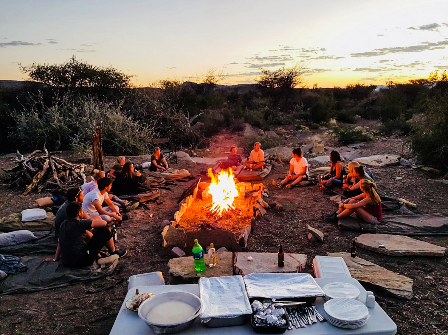 Gap year wildlife conservation - Gap year experiences - Young group hanging around the campfire