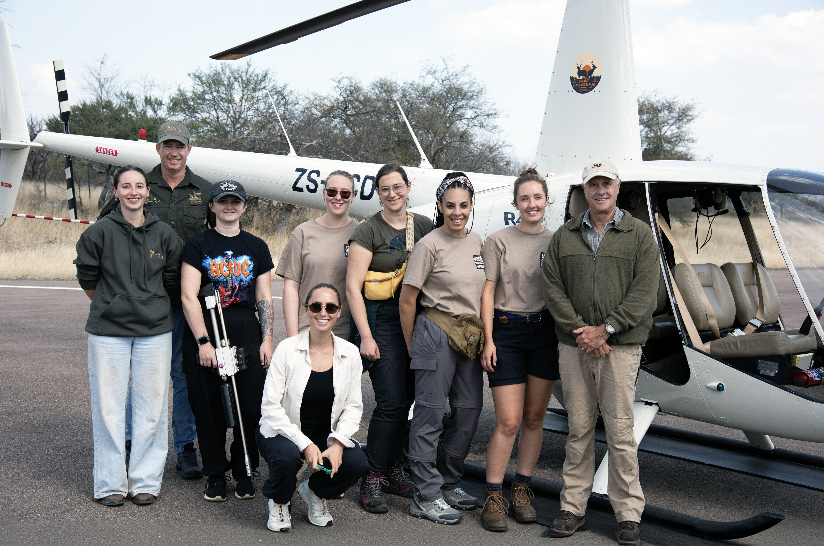 Shimongwe Expedition - vet group posing by the helicopter with a dart gun
