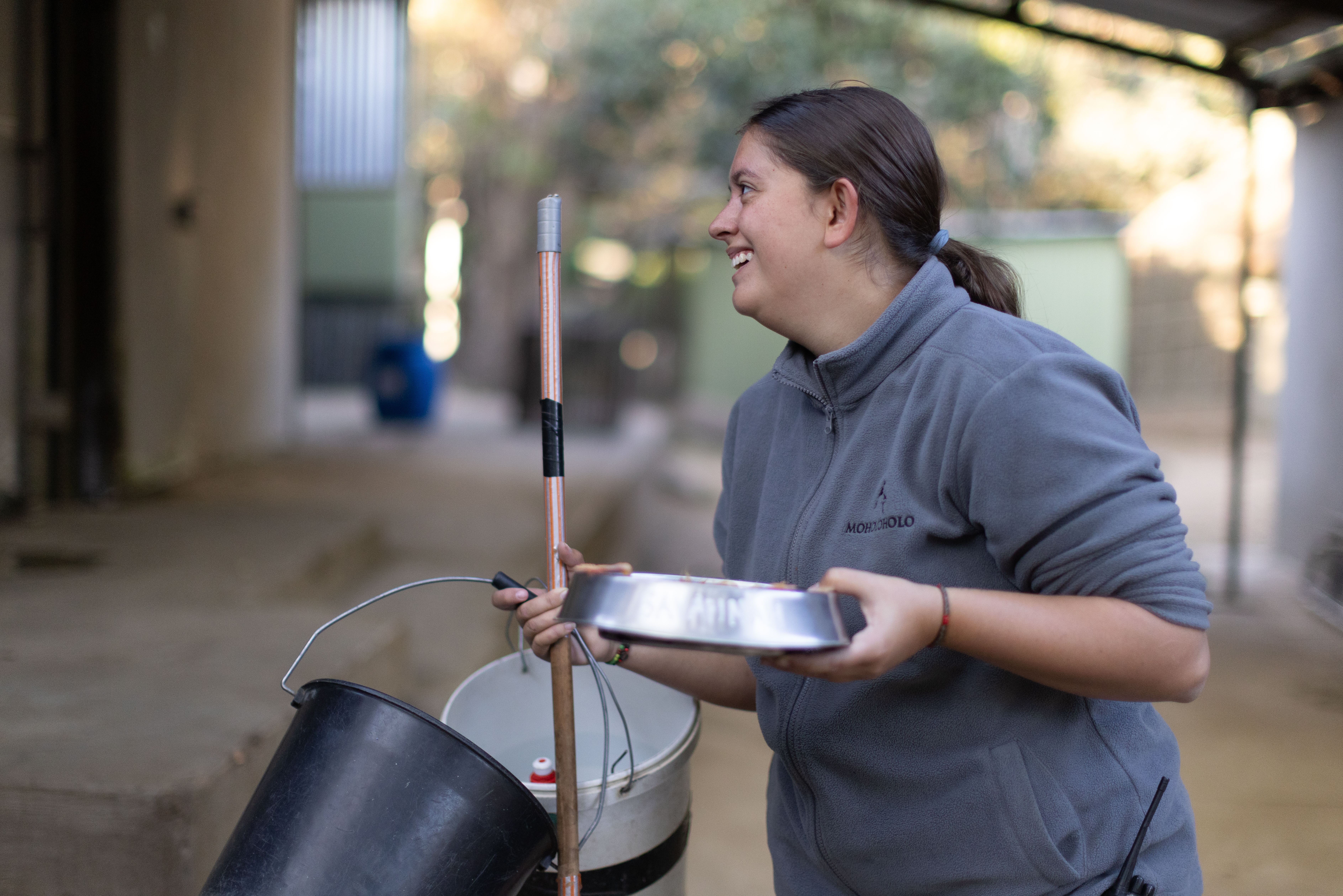 Wildlife rehabilitation volunteer opportunities - Wildlife Care & Rehabilitation - Women Smiling Whilst Cleaning and holding water bowl