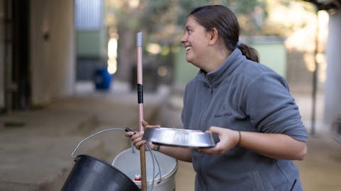 Wildlife rehabilitation volunteer opportunities - Wildlife Care & Rehabilitation - Women Smiling Whilst Cleaning and holding water bowl