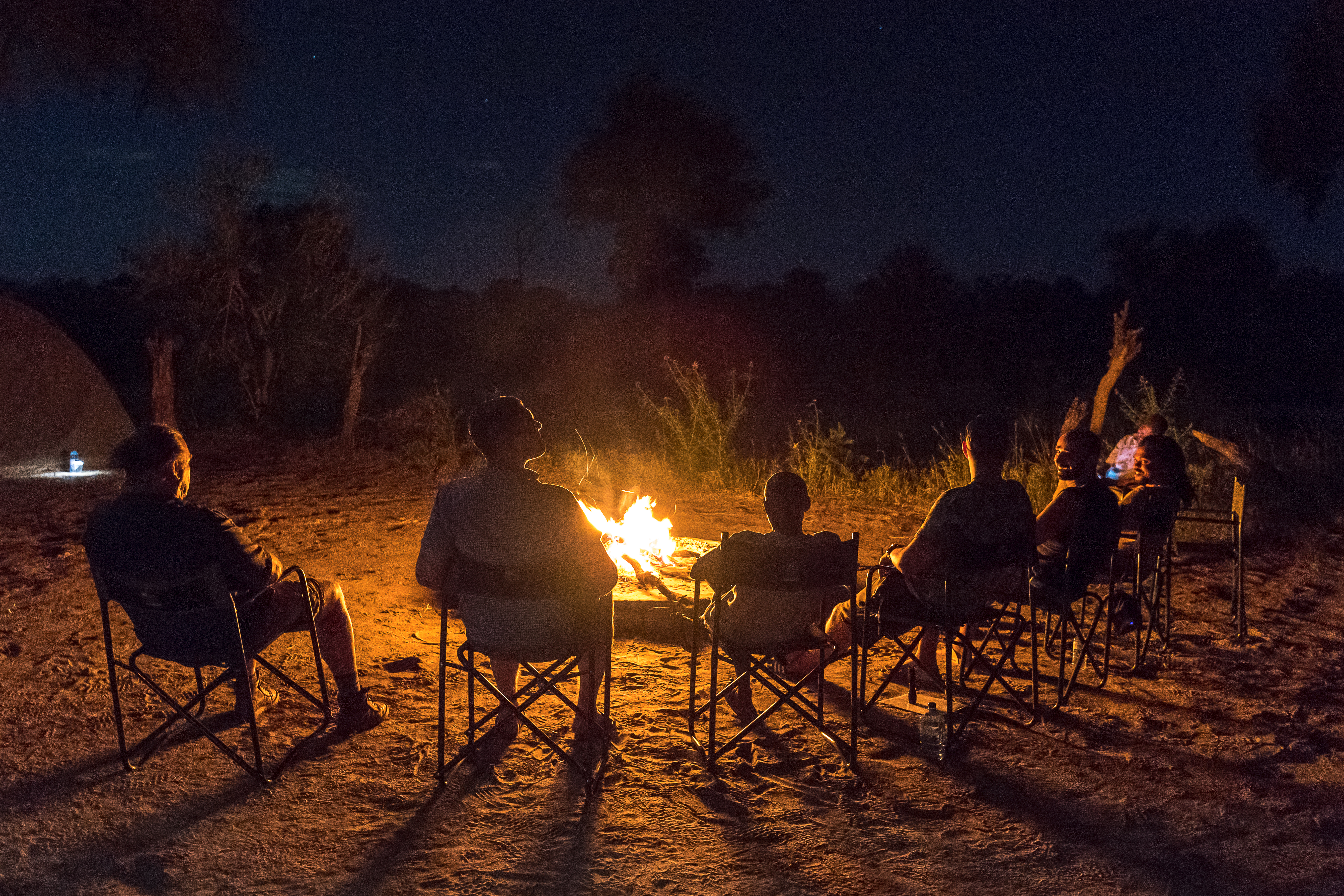 Lion conservation volunteer - Lion conservation experiences - Relaxing around the campfire at the Okavango Wilderness Project