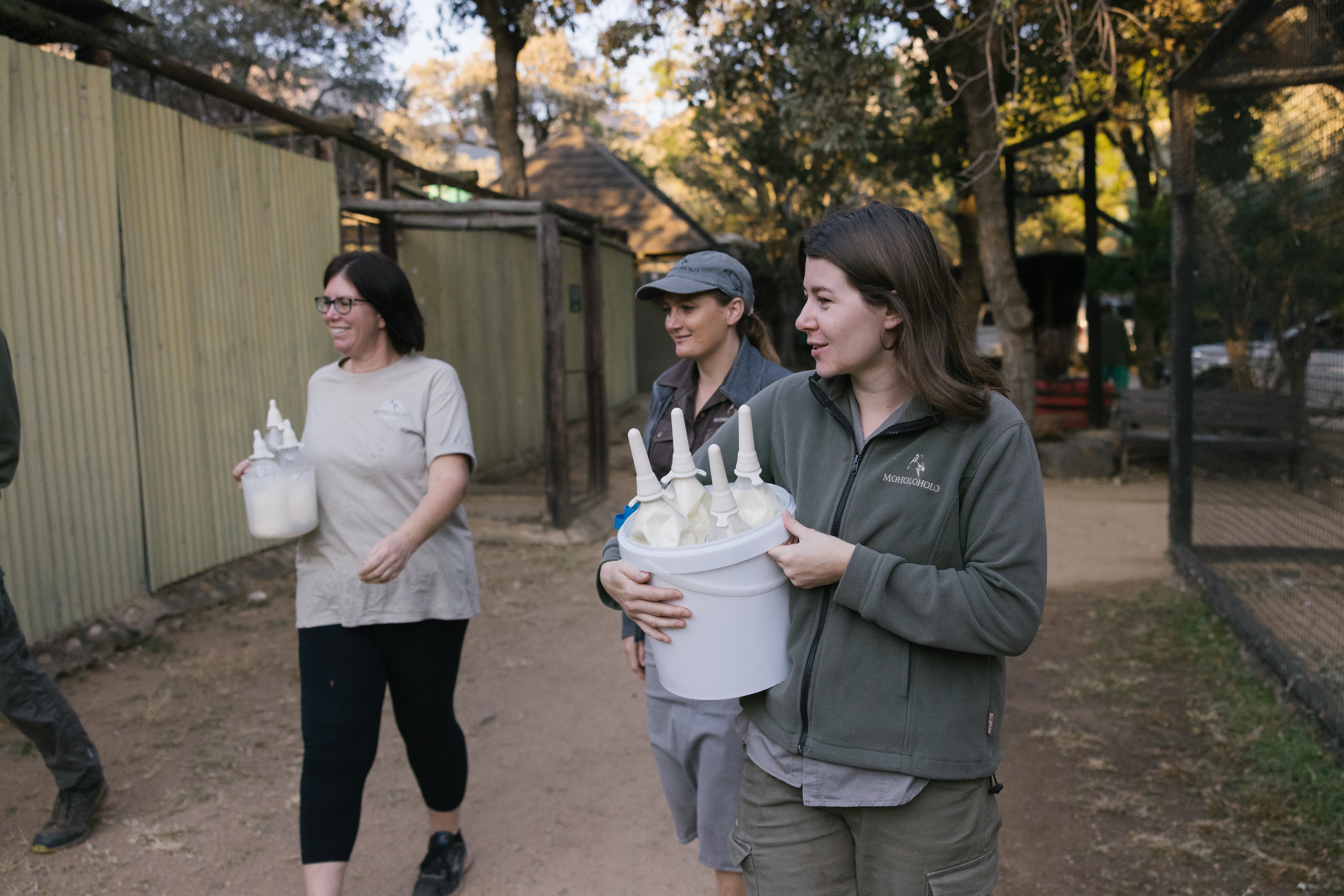 The Three Frontiers Conservation Experience - volunteers carrying milk bottles for feeding