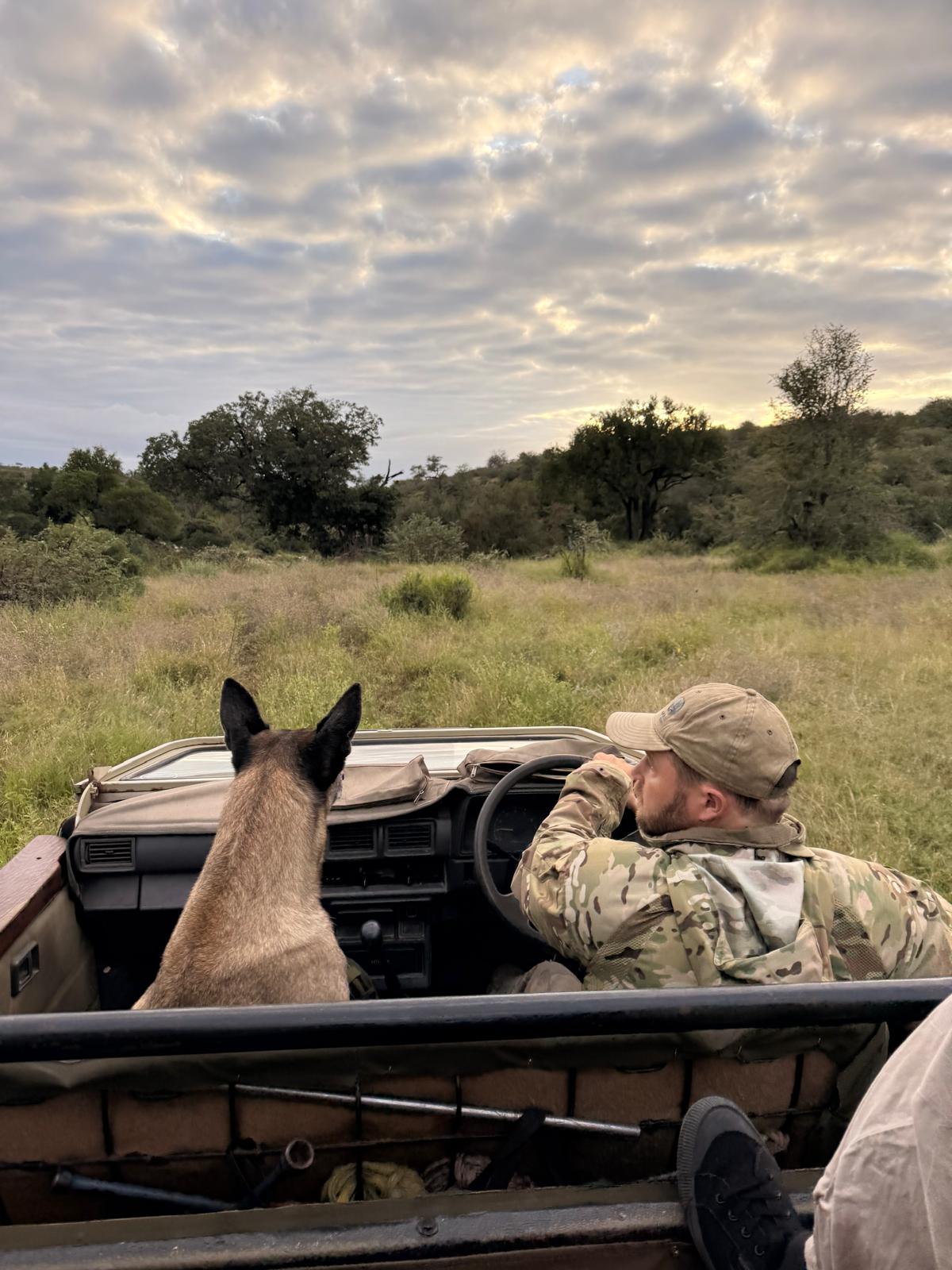 Katie Murray: Project staff and their anti-poaching dog in a game drive vehicle on Vikela project
