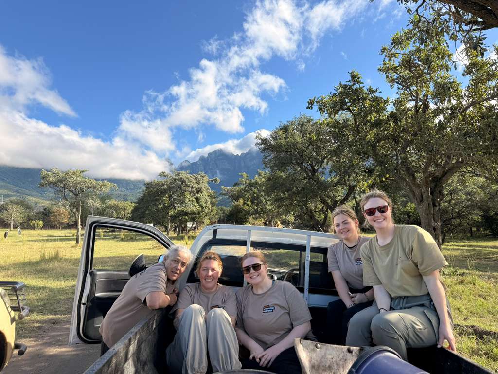 MaryClaire Murray - Group of volunteers posing for photo on vehicle at Moholoholo project