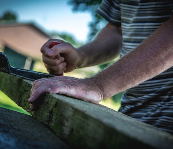 Un homme préparant travaillant sur des poutres en bois